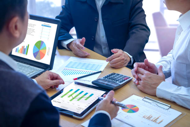 Businessmen tab on tablet touch screen to deeply reviewing a diagram or chart and financial reports for a return on investment or investment risk analysis or business performance.